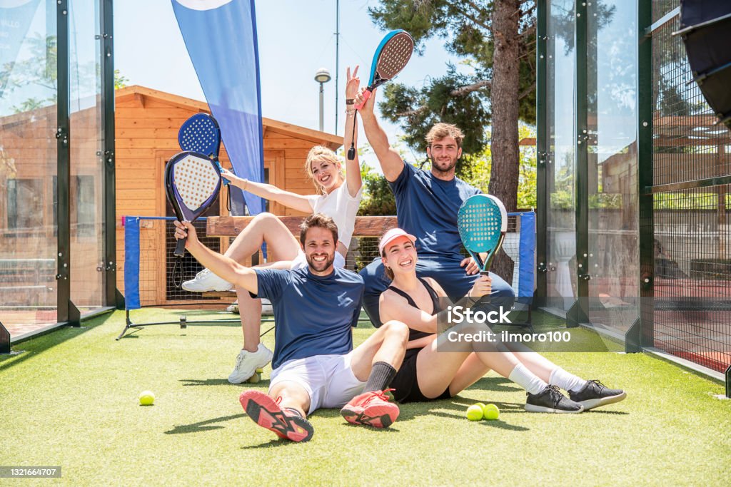 four happy winning padel tennis players celebrate after winning the match four happy winning padel tennis players celebrate after winning the match