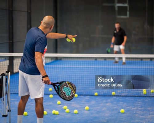 istockphoto-1330229167-1024×1024 Monitor teaching padel class to man, his student - Trainer teaches boy how to play padel on indoor tennis court